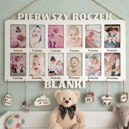 Pamiątkowa, biała drewniana ramka na zdjęcia z napisem „PIERWSZY ROCZEK BLANKI”. Ramka zawiera 12 pionowych zdjęć dziecka, opisanych kolejno od 1. do 12. miesiąca życia. Pod ramką wiszą drewniane zawieszki z metryczką, a na pierwszym planie siedzi jasny, puszysty pluszowy miś w ozdobnej muszce.