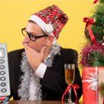 Chłopak w świątecznej scenerii dekoracji, z choinką w tle planuje wydatki z kalkulatorem.
