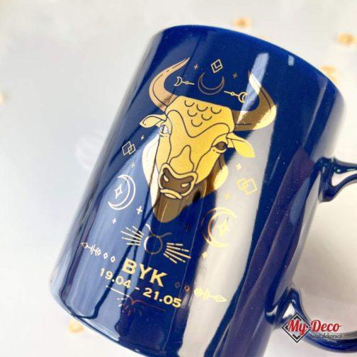 Kubek Astro ze znakiem zodiaku Byk Prezent Urodziny. Kubek granatowy ze złotym napisem i wzorem graficznym zodiakalnego byka.