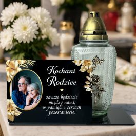 Statuetka ze Zdjęciem na Grób dla Rodziców MD1425. Personalizowana statuetka na grób z czarnej pleksi. Widoczne zdjęcie zmarłego, złote kwiaty i dedykacja, wykonane nadrukiem UV. Statuetka pełni funkcję podstawki na znicz. Pamiątka dla Mamy, Taty, Dziadka.