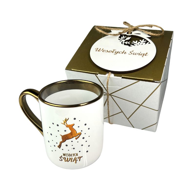 Prezent Świąteczny dla Pracowników Zestaw Kubek Świąteczny i bombka MD1650. Zestaw świąteczny z kubkiem i bombką z grawetem wesołych świąt. Kubek biały ze złotym paskiem i uchem z nadrukiem reniferka złotego.