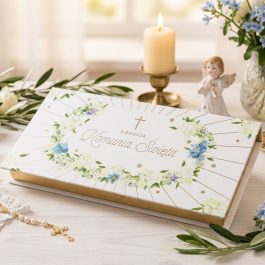 Prostokątne, eleganckie pudełko na pieniądze prezentowe na pieniądze na Pierwszą Komunię Świętą. Białe tło z delikatną złotą i zieloną grafiką roślinną oraz napisem "Pamiątka I Komunii Świętej". Pudełko jest zamknięte, widoczne pod lekkim skosem na jasnym tle.