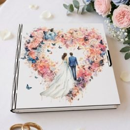 Pudełko na banknoty drewniane, otwarte pudełko prezentowe na ślub stojące na lustrzanym stole w nowoczesnej sali weselnej. Po lewej stronie widoczne są życzenia w języku polskim, po prawej trzy banknoty o nominale 200 zł. W tle bukiet kwiatów i geometryczna dekoracja.