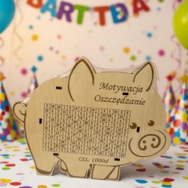 Drewniana skarbonka świnka z grawerowaną tabelą do wykreślania wpłat, cel oszczędnościowy 1000 zł, wykonana z naturalnej płyty HDF.