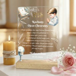 Podziękowanie dla chrzestnych. Pamiątka Pierwszej Komunii Świętej z nadrukiem UV. Przezroczysta statuetka akrylowa na drewnianej podstawie. Grafika modlącego się chłopca, modlitewnika, symboli IHS i kielicha. Tekst podziękowania dla Ojca Chrzestnego od Maksymiliana (data: 24.05.2026). Zdjęcie w otoczeniu świecy, różowych róż i gipsówki.