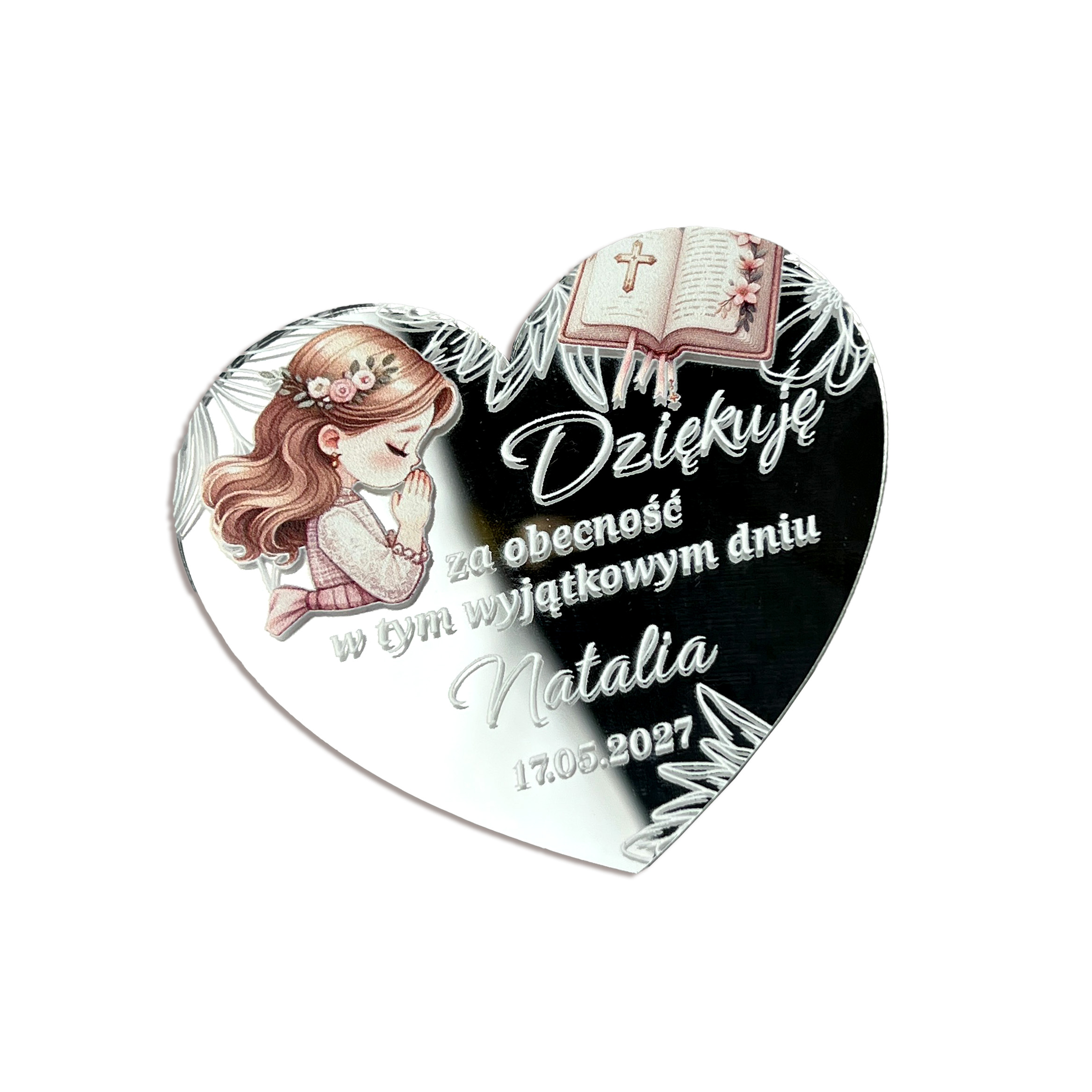 Prezenciki dla gości. Personalizowany magnes na podziękowanie komunijne w kształcie serca ze srebrnej pleksi lustrzanej, z kolorowym nadrukiem modlącej się dziewczynki w wianku, otwartą Biblią, ozdobnym nadrukiem i Polish text "Dziękuję za obecność w tym wyjątkowym dniu Natalia 17.05.2027", położony na plaster drewna i otoczony białymi peoniami i gipsówką, w jasnym świetle dziennym.