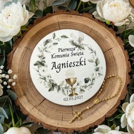 Podziękowanie dla gości na komunię. Spersonalizowany magnes komunijny w kształcie serca z białego HDF, prezentowany na naturalnym plastrze drewna w otoczeniu gałązek eukaliptusa i różańca. Na magnesie widoczny jest trwały nadruk UV: złota gołębica, kielich eucharystyczny oraz różowe kwiaty. Tekst na magnesie: "Dziękuję za obecność w tym wyjątkowym dniu, Jakub, 17.05.2027".