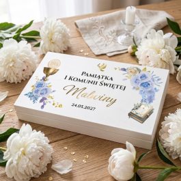 Pamiątkowe pudełko na pieniądze z okazji Pierwszej Komunii Świętej dla dziewczynki i chłopca. Na wieku personalizowany nadruk w stylu akwareli przedstawiający niebieskie kwiaty piwoni, złoty kielich ihs i biblię. Widoczny napis: "Pamiątka I Komunii Świętej Pawła 24.05.2027". Produkt pokazany na białym tle w rzucie izometrycznym.