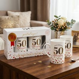Zestaw dwóch białych ceramicznych kubków ze złotym napisem „50 lat razem” zapakowany w ozdobne pudełko prezentowe na złotą rocznicę ślubu.