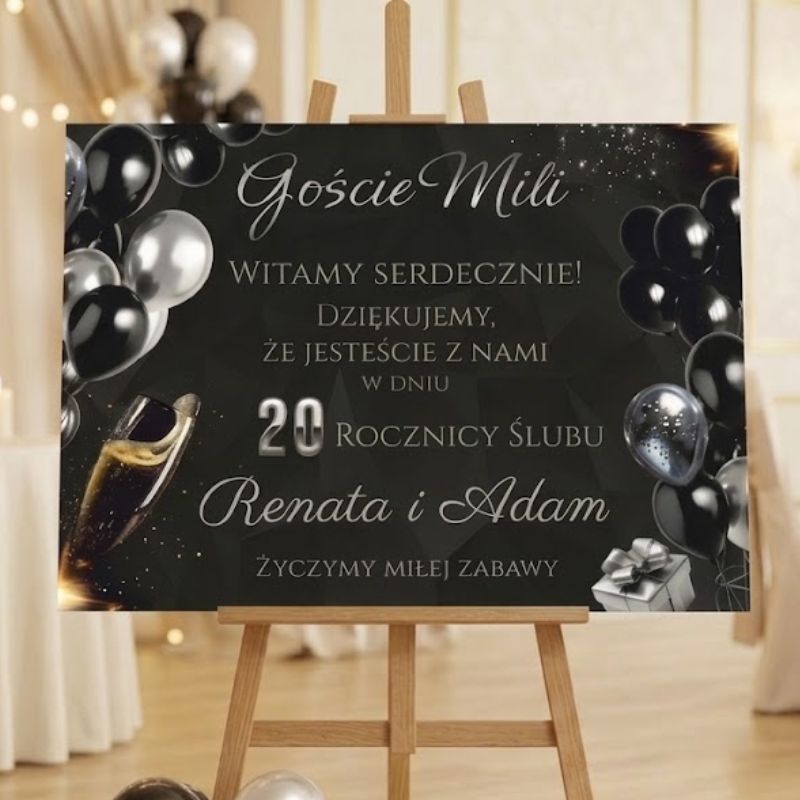 Elegancka Tablica Powitalna na Rocznicę Ślubu 70x50 cm Personalizowana MD1976. Personalizowana tablica powitalna na 20. rocznicę ślubu z imionami Renata i Adam, z eleganckim motywem czarnych i srebrnych balonów oraz szampana, stojąca na drewnianej sztaludze.