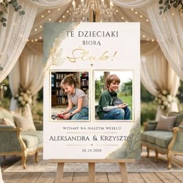 Tablica Powitalna na Wesele Personalizowana ze Zdjęciami Boho. Spersonalizowana tablica powitalna na wesele stojąca na drewnianej sztaludze. Tablica ma białe tło ze złotymi grafikami liści i zawiera dwa zdjęcia pary jako dzieci oraz napis po polsku: „TE DZIECIAKI BIORĄ Ślub! Witamy na naszym weselu! ALEKSANDRA & KRZYSZTOF 26.10.2026”. Wokoło sztalugi widać dekoracje z trawy pampasowej i białych kwiatów na drewnianej podłodze.